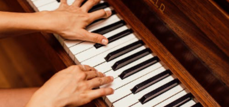 Handen op een piano tijdens het pianospelen